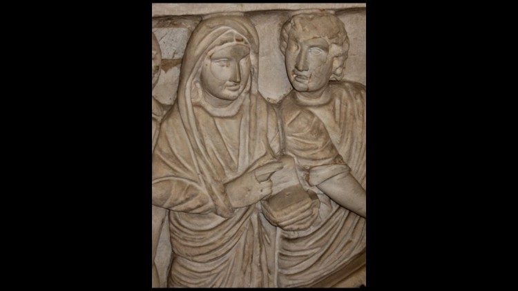 （图2 浮雕中关于这位已故女性雕刻的细节：她左手持一本典籍，右手做着演讲的手势，同时基督在其身边与其交谈）